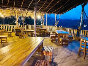 a restaurant with wooden tables and chairs on a deck at The Chill Heights Ramboda in Ramboda