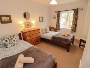 a bedroom with two beds and a window at Two Town End in Penrith