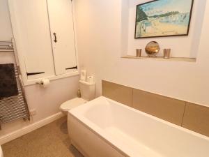 a white bathroom with a tub and a toilet at Two Town End in Penrith +47 photos