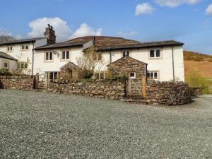 a large white house with a stone wall at Two Town End in Penrith