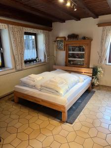 a bedroom with a large bed in a room with windows at Ferienhaus Natternberg Spacious apartment large living room 4 bedrooms garden quiet near Deggendorf in Deggendorf