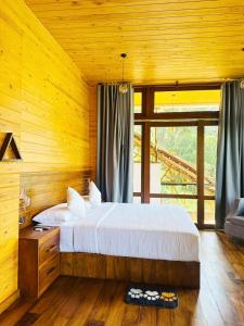 a bedroom with a bed and a large window at The Chill Heights Ramboda in Ramboda