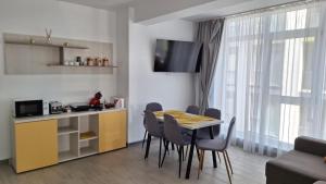 a kitchen and dining room with a table and chairs at Apartament Alezzi in Năvodari