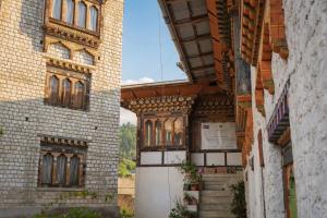 an alleyway between two brick buildings with windows at Samyae Resort in Jakar