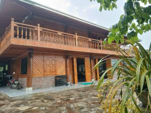 a wooden house with a balcony on top of it at Sapa Rock Hill Homestay in Tả Van