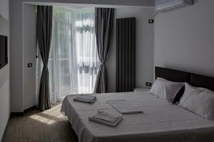 a bedroom with a bed with two towels on it at Apartament Alezzi in Năvodari +67 photos