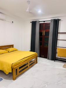 a bedroom with a yellow bed and a window at K won Villa in Busse