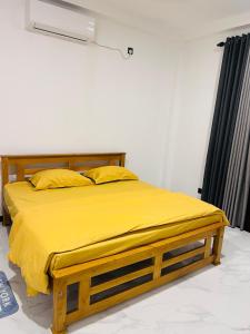 a bed with yellow sheets and pillows in a room at K won Villa in Busse