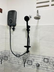 a bathroom with a microphone on the floor at Sawmya Guest House in Randeniya