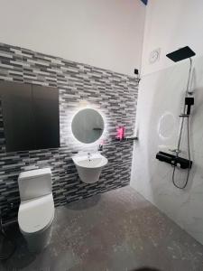 a bathroom with a toilet and a sink and a mirror at K won Villa in Busse