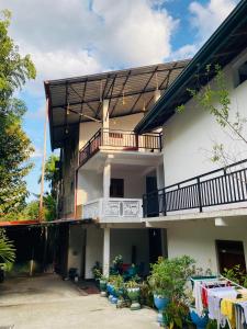 an apartment building with a balcony and clothes on a table at Sawmya Guest House in Randeniya