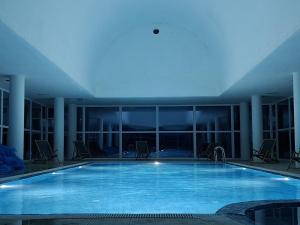 a large swimming pool with chairs in a building at Делта СПА in Banya