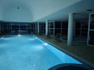 a large swimming pool in a building at night at Делта СПА in Banya +18 photos