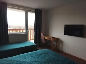 a hotel room with a bed and a desk and a television at Делта СПА in Banya
