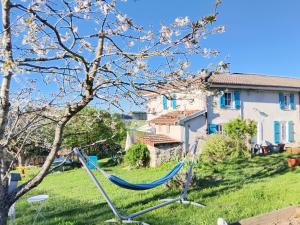 a hammock in a yard next to a house at La chambre du lac in Meaux-la-Montagne