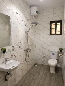 a bathroom with a shower and a toilet and a sink at Adesta Suites in Ilorin