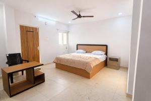 a bedroom with a bed and a table and a chair at Vihari Foodway INN in Gooty