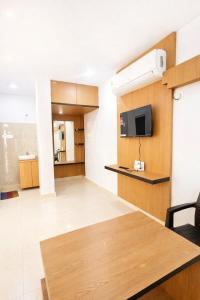 a living room with a table and a tv at Vihari Foodway INN in Gooty
