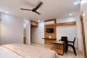 a bedroom with a bed and a ceiling fan at Vihari Foodway INN in Gooty