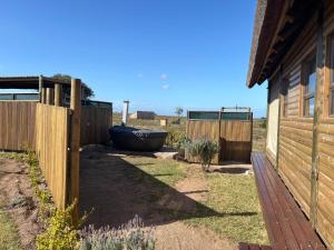 a yard with a fence and a boat next to a house at Kuierbos in Gouritzmond +10 photos