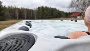 a person in a jacuzzi tub with snow at Warmińska Polana - Nowy, całoroczny dom na 2 ha łące dla 8 osób - Gietrzwałd in Gietrzwałd