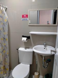 a small bathroom with a toilet and a sink at Casa FAM in Laoag +54 photos