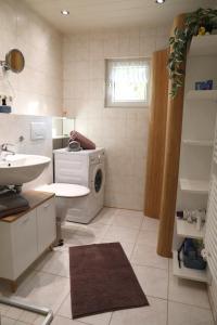 a bathroom with a sink and a washing machine at Häuschen im Grünen in Bansin +12 photos