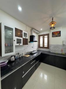 a large kitchen with black counter tops in a room at Bunkyard rishikesh in Rishīkesh