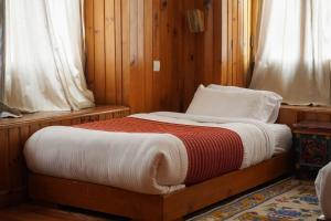 a small bed in a room with wooden walls at Samyae Resort in Jakar +2 photos