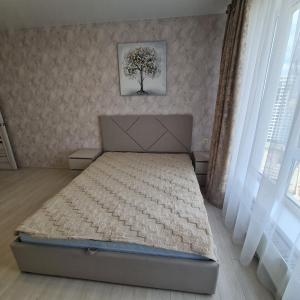 a bedroom with a bed with a tree on the wall at Апартаменты in Odesa
