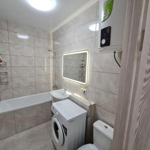 a bathroom with a toilet and a sink and a tub at Апартаменты in Odesa +8 photos