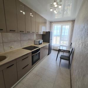 a kitchen with a sink and a table and a counter at Апартаменты in Odesa