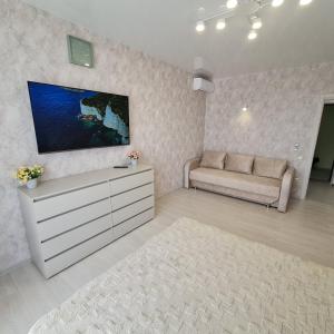 a living room with a tv and a couch at Апартаменты in Odesa
