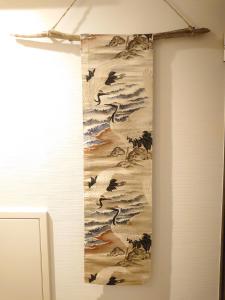 a painting hanging on a wall with birds on it at the UNIT5 HOUSE Roppongi in Tokyo