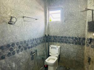 a bathroom with a toilet and a window at SRI Villa in Busse