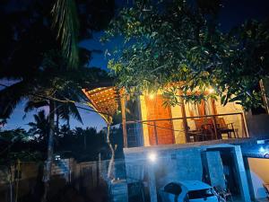 a house with lights on the side of it at night at SRI Villa in Busse