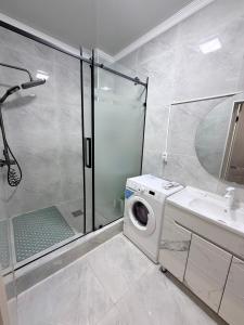 a bathroom with a washing machine and a shower at Frunze Residence in Osh