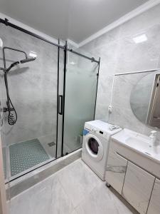 a bathroom with a washing machine and a shower at Frunze Residence in Osh