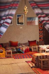 uma sala de estar com um sofá e mesas num quarto em Auberge Migusta em Skoura