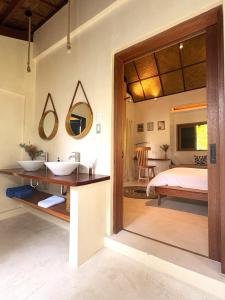 a bathroom with a sink and a bed in a room at Confluence Siargao in General Luna