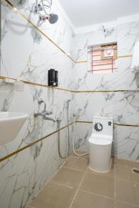 a bathroom with a toilet and a sink at Odilia Apartelle in Bangalore +25 photos