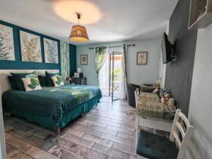 a bedroom with a bed and a television and a table at Le balcon des cimes in Adast