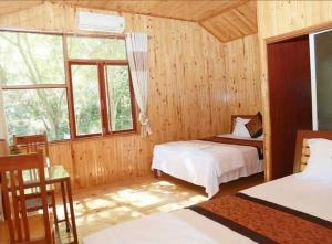 a bedroom with two beds and a window at Phong Nha Midtown Hotel in Phong Nha