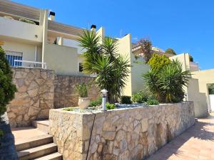 a stone retaining wall in front of a house at ALBA MARINA Experience Peñiscola in Peniscola
