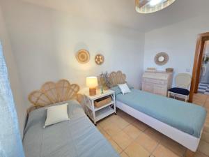 a bedroom with two beds and a table and a chair at ALBA MARINA Experience Peñiscola in Peniscola
