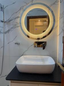 a bathroom with a white sink and a mirror at The Hotel Art 8 in Pātan +26 photos