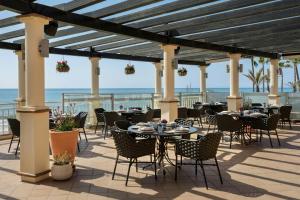 a patio with tables and chairs with the ocean in the background at Marriott's Marbella Beach Resort in Marbella