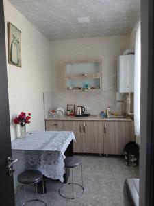 a kitchen with a table and two stools in it at Guest house Babaka in Sighnaghi