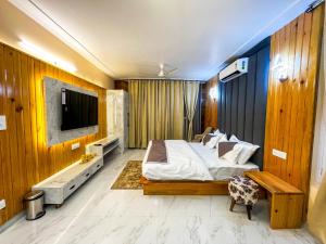 a bedroom with a large bed and a tv in it at Mount kirola stay in Bhowāli