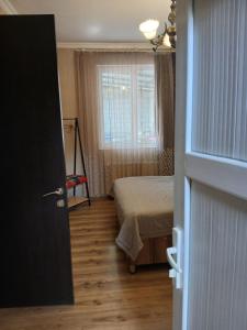 a small bedroom with a bed and a window at Guest house Babaka in Sighnaghi